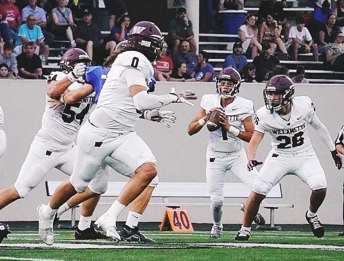 Willamette's Zeke Thomas (1) looks to pass toward Kawai Chamberlin (0) in Friday's win at South Medford. (Photo by Ashlyn Lytle)