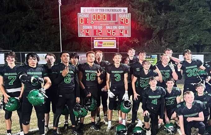 Rainier players pose before the scoreboard after holding off Corbett 101-90 on homecoming night. (Courtesy Rainier HS)