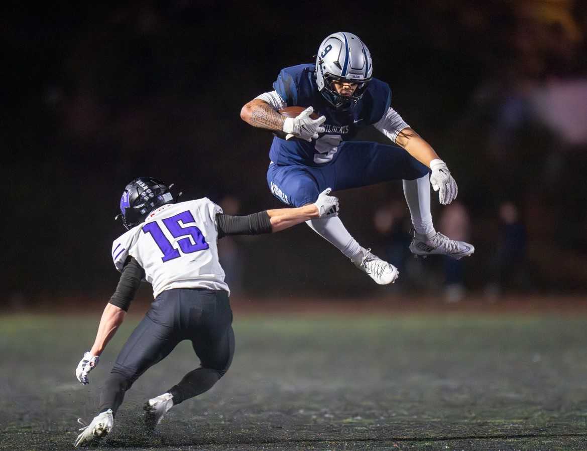 Wilsonville's Roman Kealoha (9) avoids Ridgeview's Seraph Homann (15) in Friday's 5A playoff game. (Photo by Michael Williams)