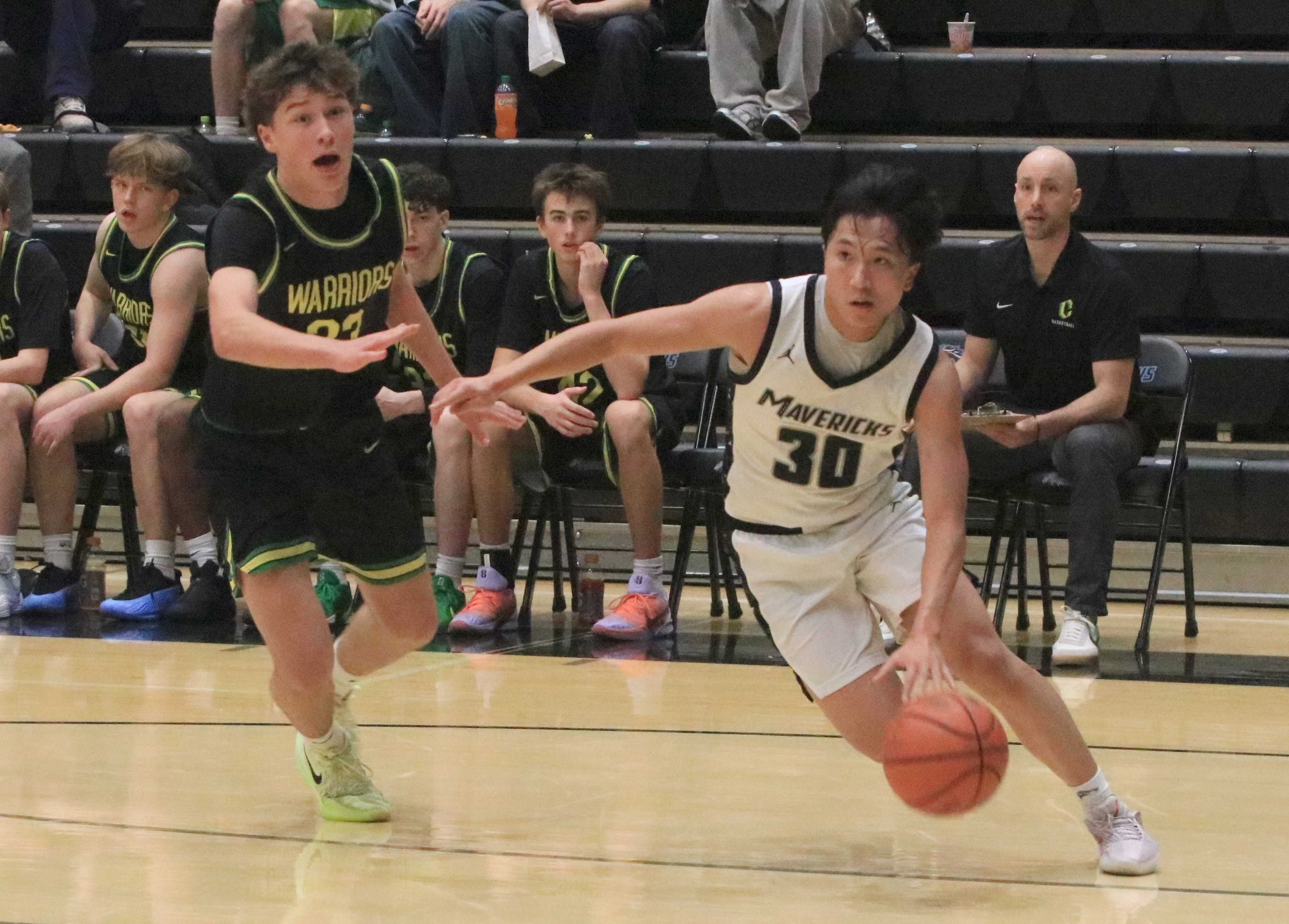 Mountainside's Eli Vizconde (30) drives past Cleveland's Holland Lounsbury during Friday's home game. (Photo by Jim Beseda)