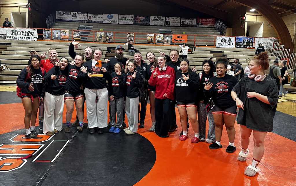 The North Salem girls wrestling team celebrates with the Lady Dragon first-place trophy. (Photo from Andrew Pickett)