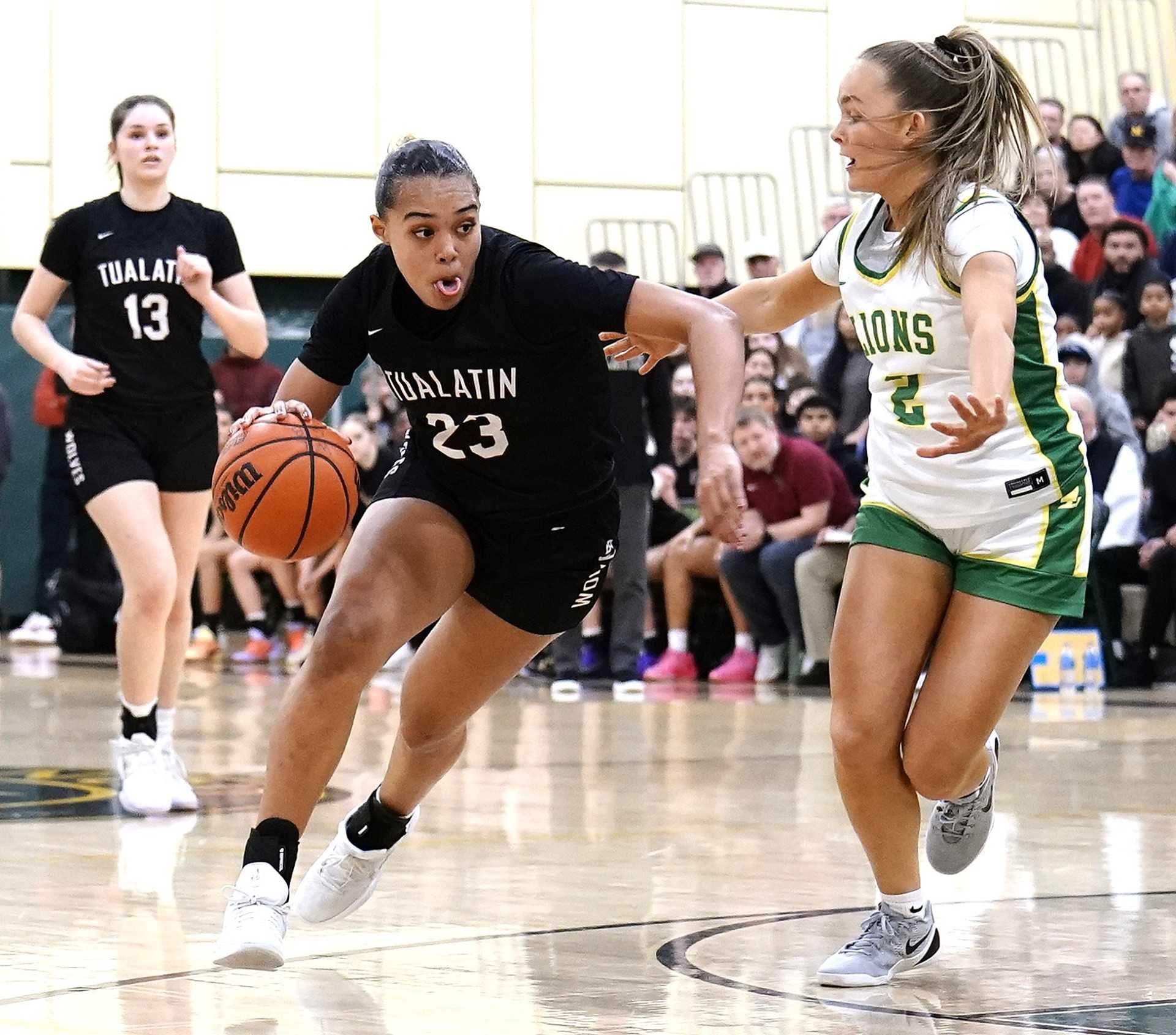 Tualatin's Kendall Dawkins, driving against West Linn's Piper Beall, had a team-high 15 points Tuesday. (Photo by JR Olson)