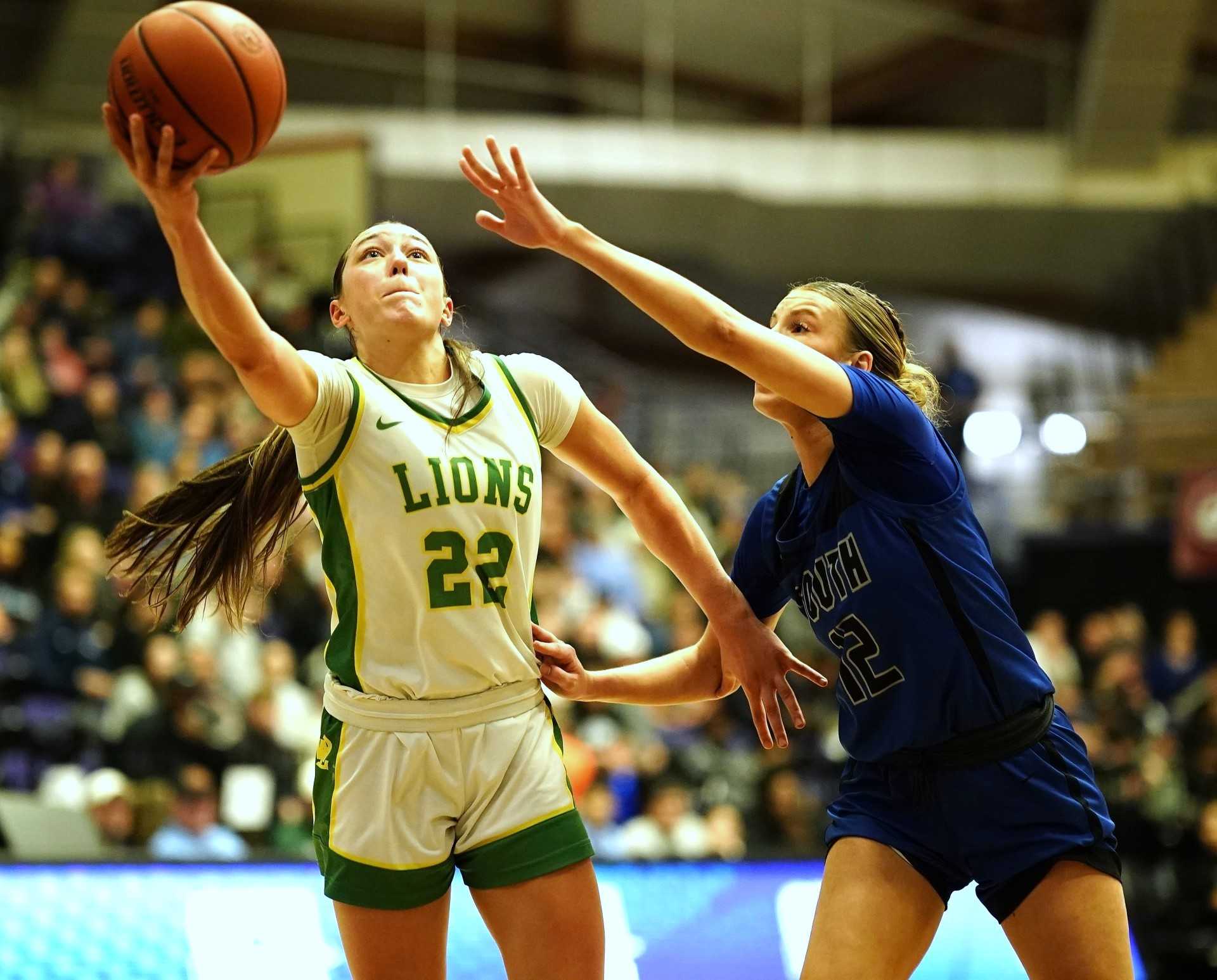 West Linn's Kaylor Buse (22), driving past South Medford's Dyllyn Howell, scored 23 points Saturday night. (Photo by J.R. Olson)