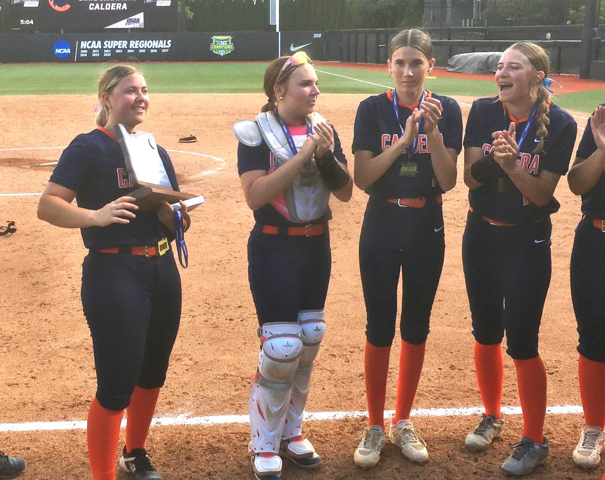 Caldera's Brooke Chapin (left) holds the state championship trophy after Saturday's 9-4 win over Wilsonville.