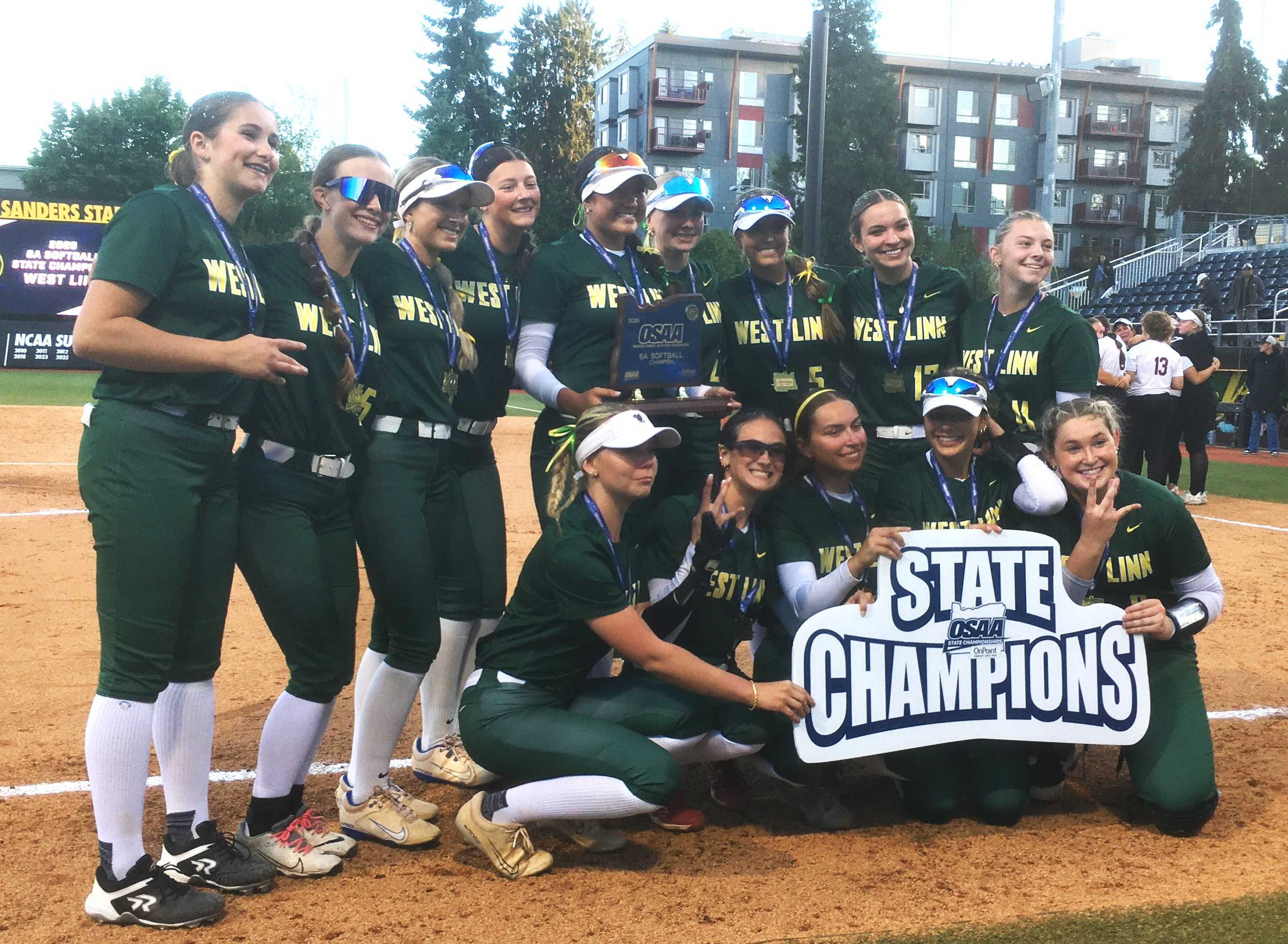 West Linn players pose with the state championship trophy after their 6-2 win over Sherwood on Saturday night.