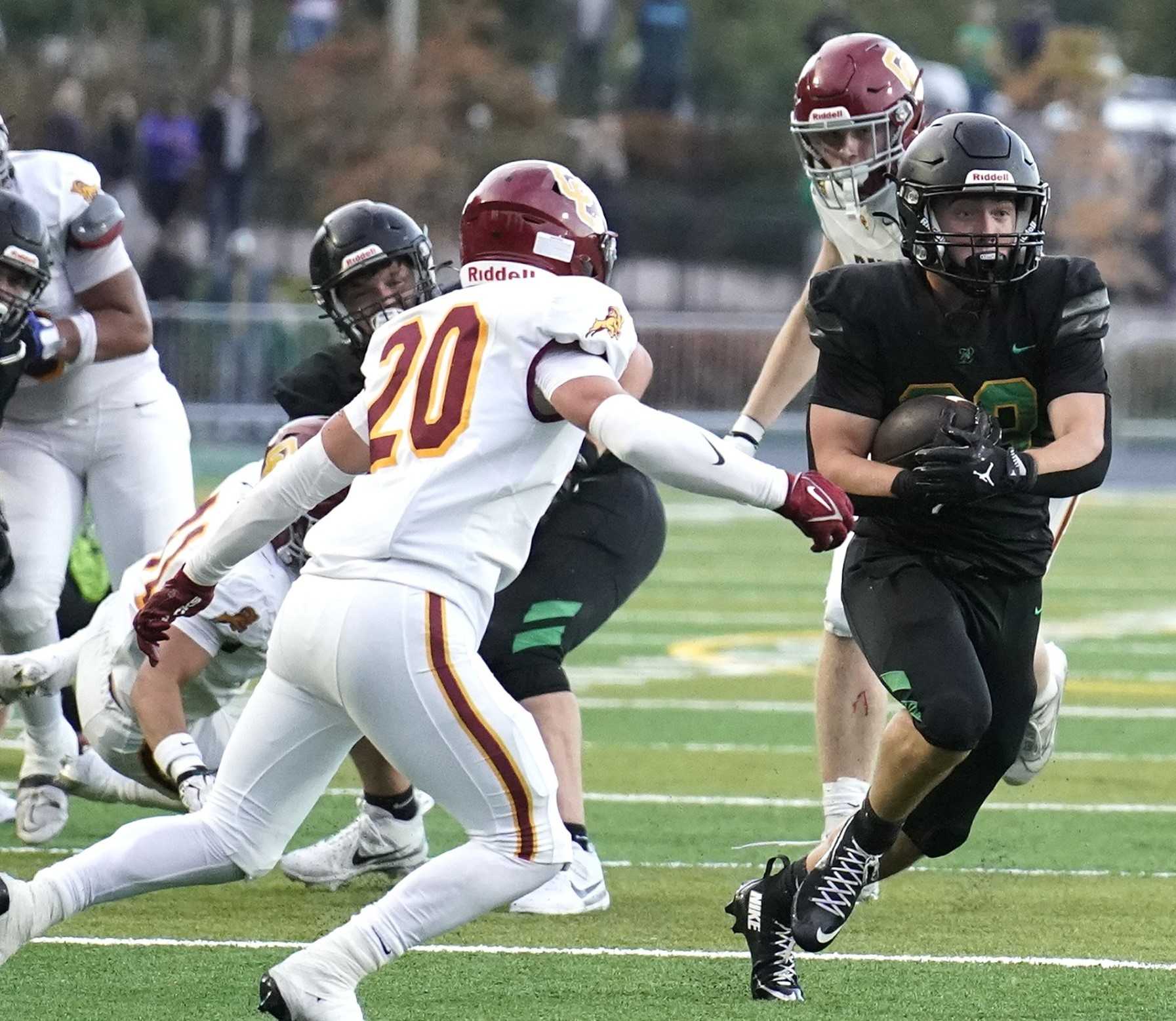 West Linn's Cohen Bissell turns up field against Central Catholic's Will Emerson (20) on Friday night. (Photo by JR Olson)